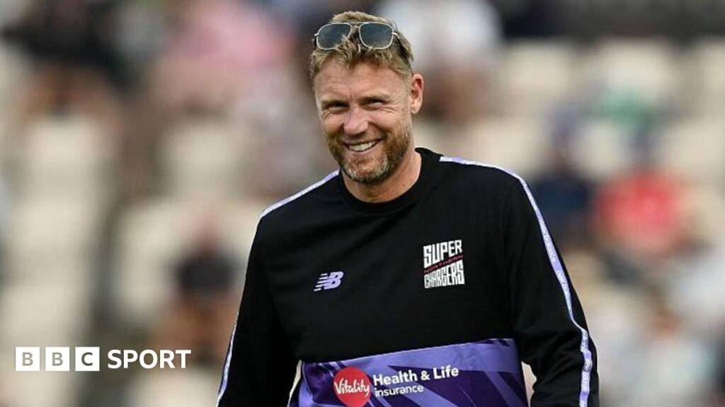 Andrew Flintoff smiling while wearing a Northern Superchargers shirt and a pair of sunglasses on top of his head.