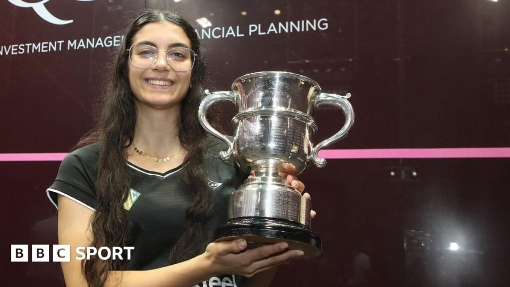 Amino Orfi holding her trophy and smiling