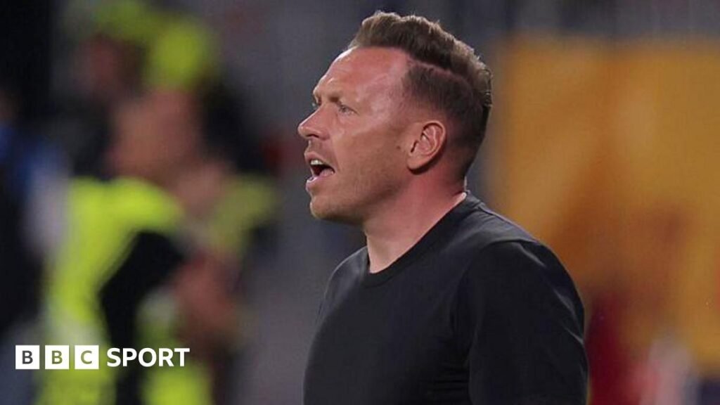 Craig Bellamy says Wales must be better after Romania woe Wales boss Craig Bellamy reacts with an open-mouthed expression as he stands in a round-neck black top
