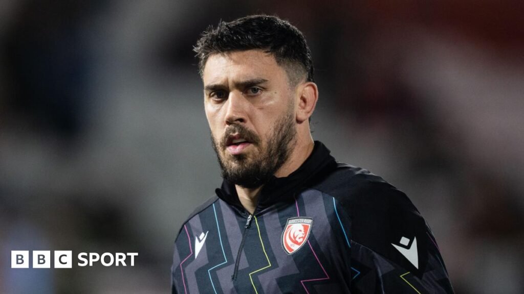 Gloucester rugby lock Matias Alemanno looks on during the warm-up for a Premiership Rugby game, wearing a black quarter-zip training top