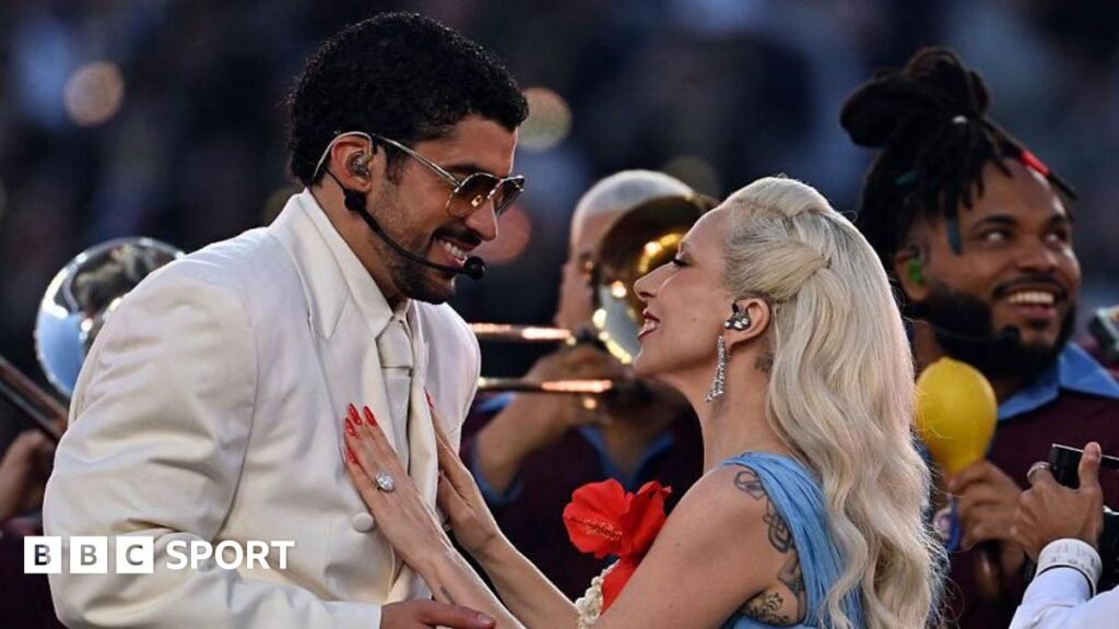 Bad Bunny and Lady Gaga smiling at each other as they perform the half-time show at Super Bowl 60