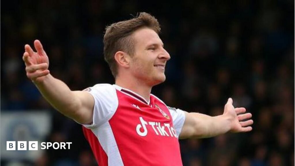 Paul Mullin with outretched arms celebrates a goal for Wrexham in 2021
