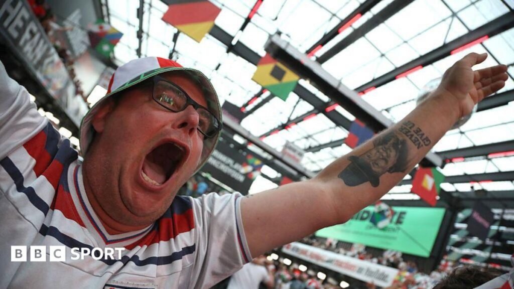 A football fan celebrates while watching the World Cup in a bar