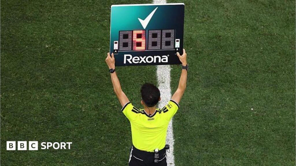 The fourth official holds up the substitution board during the Fifa World Cup match between Iran and New Zealand