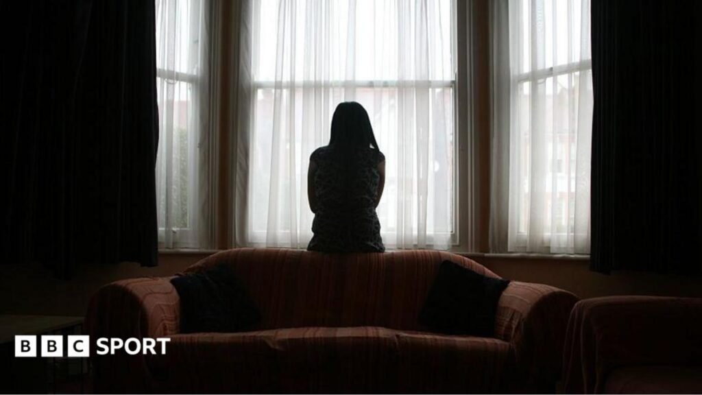Domestic abuse: The harrowing dark side of England’s World Cup exit A woman sits on the back of a sofa, looking out of the window in fear of her partner, coming home after football.