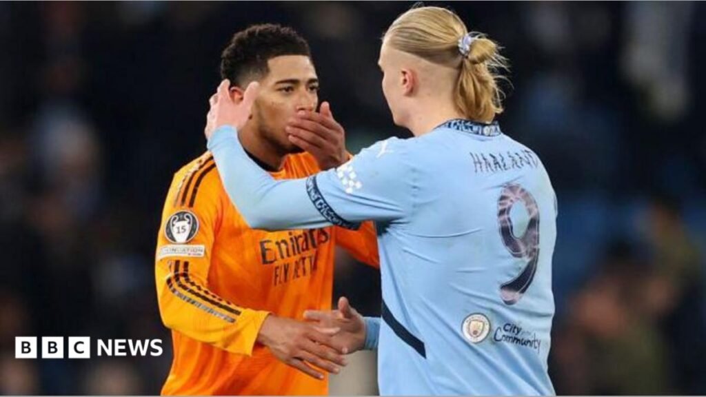 Jude Bellingham covers his mouth talking to Erling Haaland who is about to hug him