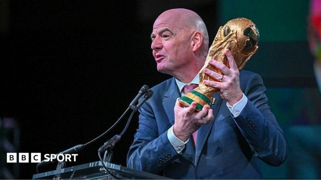Gianni Infantino holds the World Cup trophy