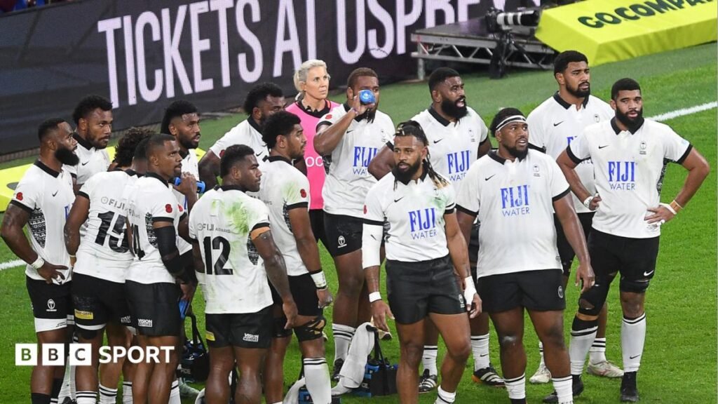Group of Fiji players in black and white kit on the field in 2024