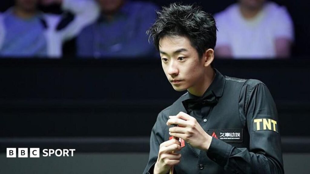 Shanghai Masters: Wu Yize edges past Shaun Murphy into semi-finals Wu Yize, wearing a black shirt and bowtie, chalks his cue with his left hand