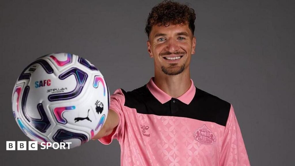 Thomas Meunier: Sunderland sign experienced Belgian defender on two-year deal Thomas Meunier holds a ball outstretched in his right hand. He is wearing a pink Sunderland jersey