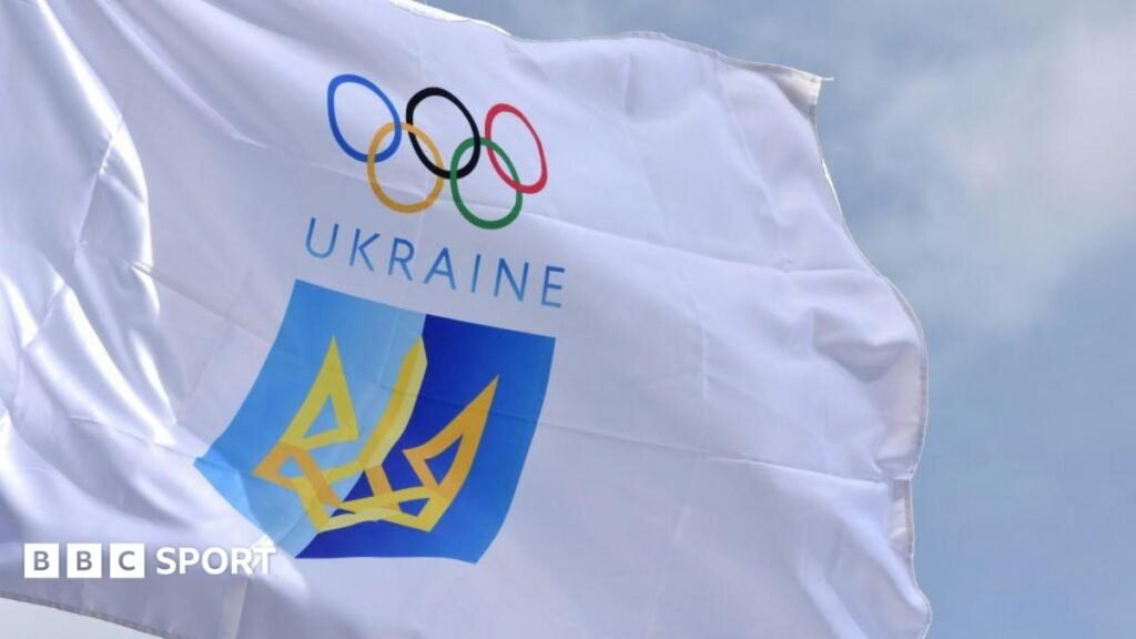 White flag of the National Olympic Committee of Ukraine, featuring the Olympic rings above the word Ukraine and a blue and yellow crest