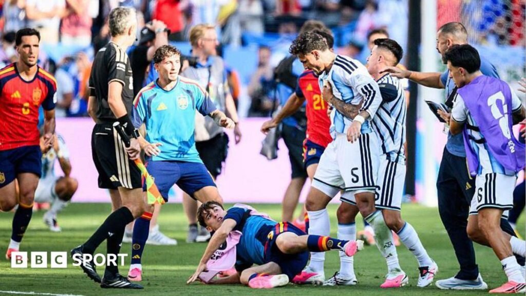 Leandro Parades (fourth right) is pulled away by teammates with a Spain player on the floor at his feet
