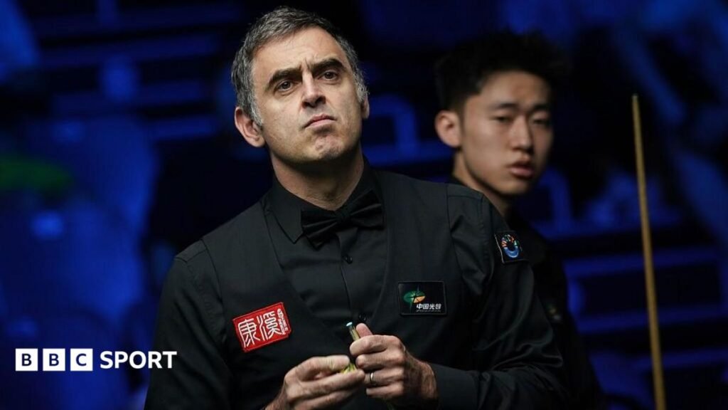 Ronnie O'Sullivan chalking his cue