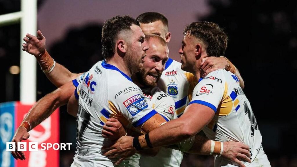 Leeds Rhinos players in white shirts celebrate a try