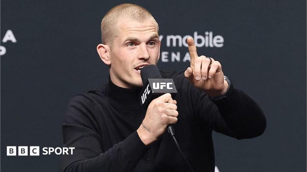 UFC 330: Ian Machado Garry booed heavily at news conference Ian Machado Garry talks into a microphone and holds up one finger