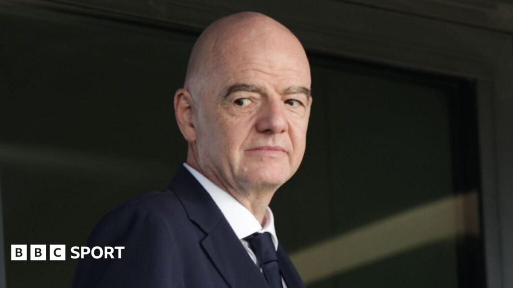 Head and shoulders view of Gianni Infantino looking to his right, as he wears dark jacket and tie and a white shirt