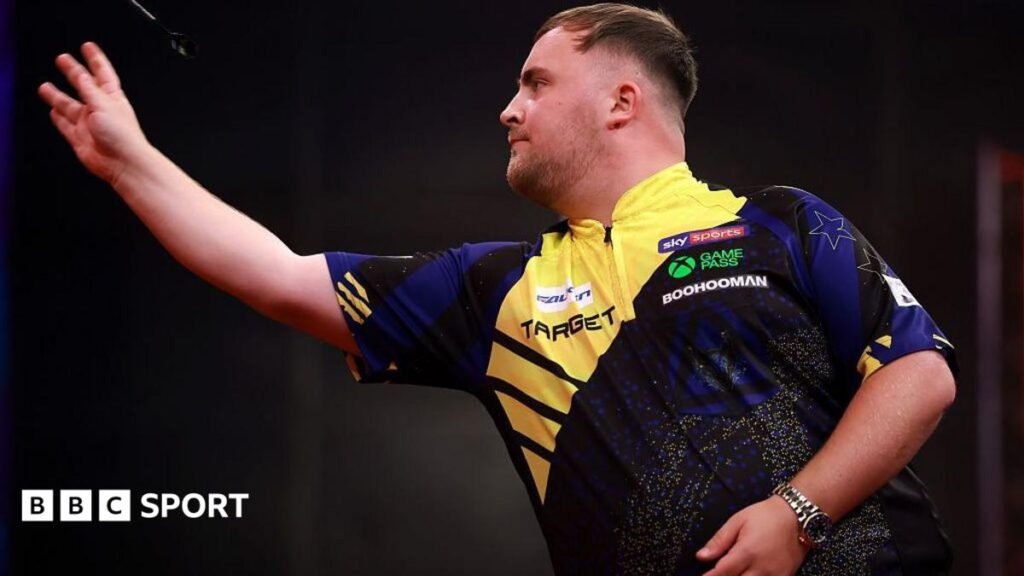Luke Littler throws a dart during a competition