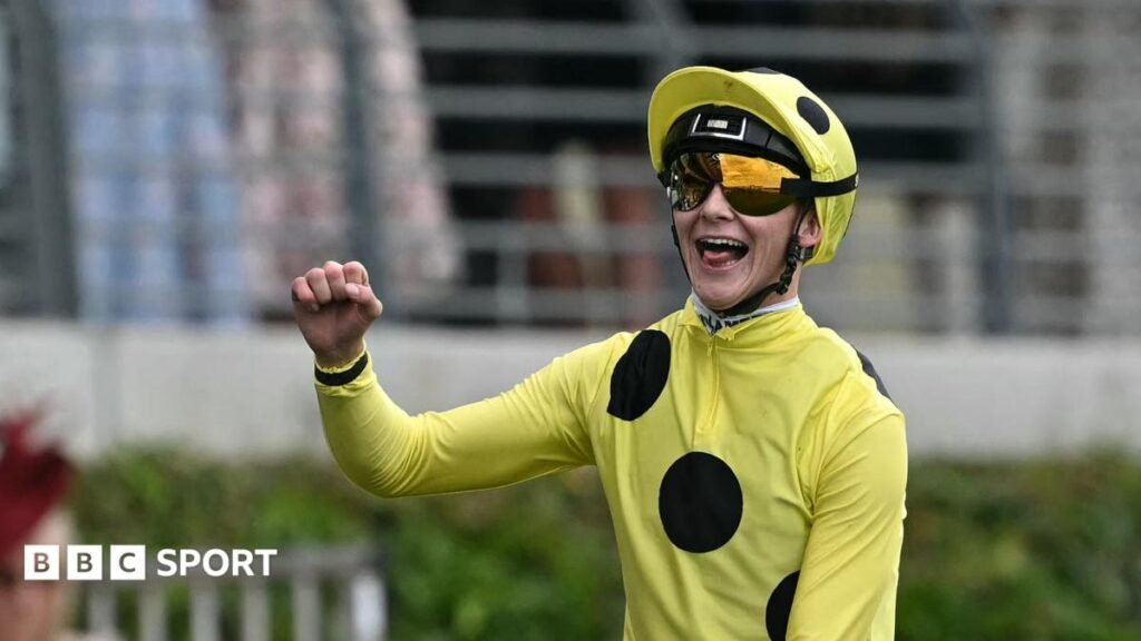 Billy Loughnane wearing a riding helmet, sunglasses and a yellow top with three black spots running diagonally across his chest