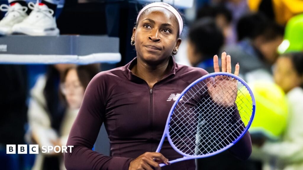 Coco Gauff pats her racket against her hand with a forlorn expression