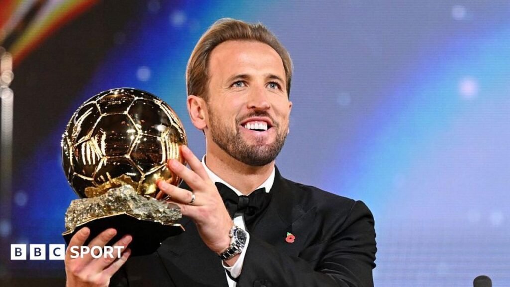 Harry Kane holds up the Ballon d'Or trophy