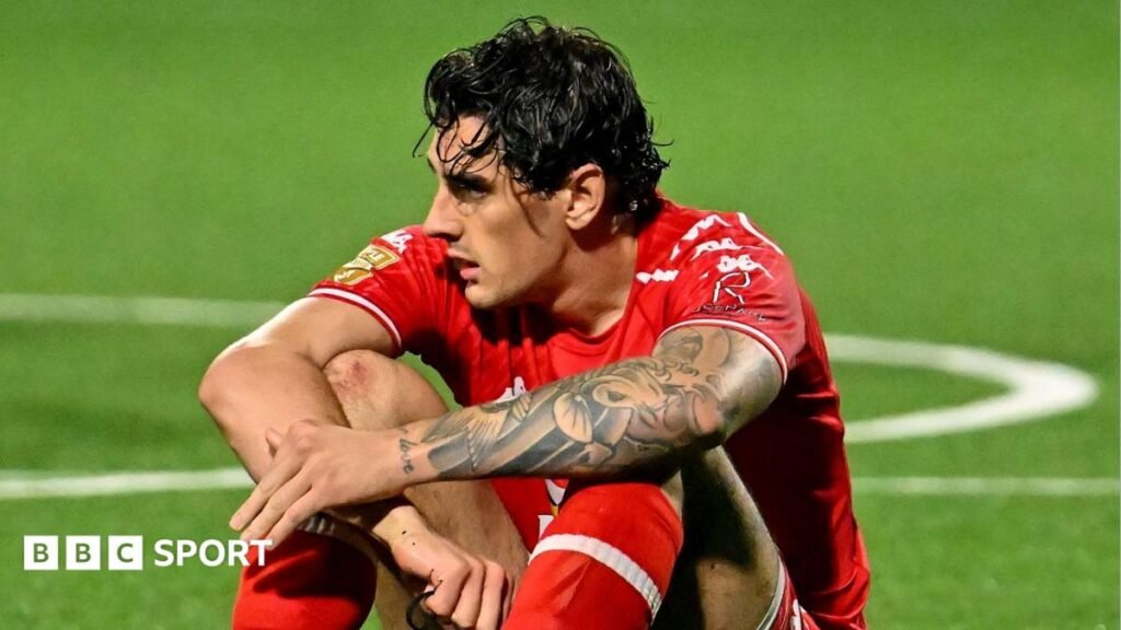 Matt Ridley of Larne sitting on the pitch